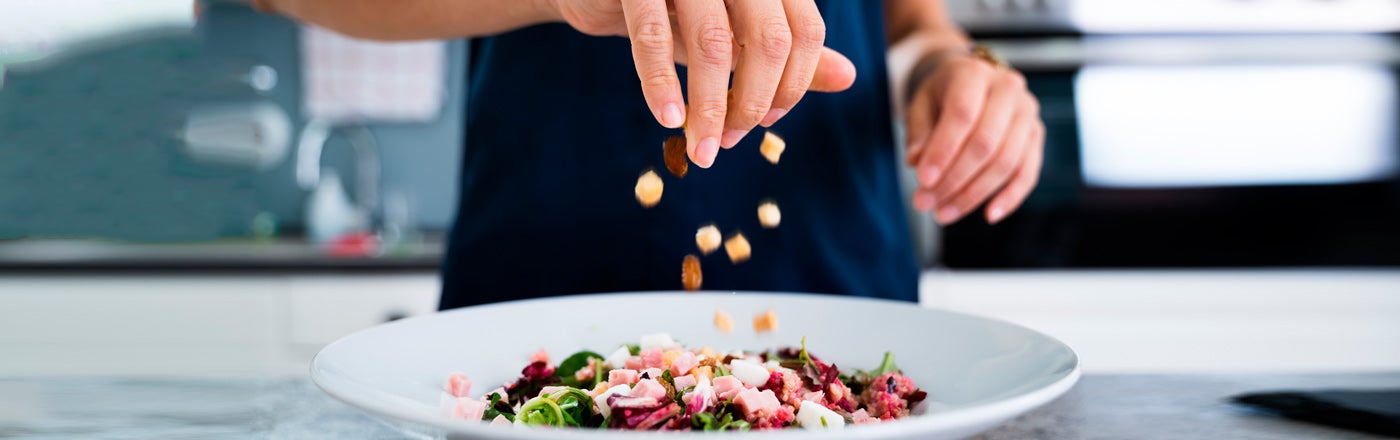 Contigo_Banner_-cocinera-sin-rostro-vertiendo-vinagre-mientras-prepara-ensalada-vegetariana-como-alimentación-balanceada_1400x440_0.jpg