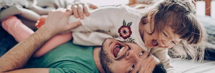 Padre jugando y riendo con su hija 