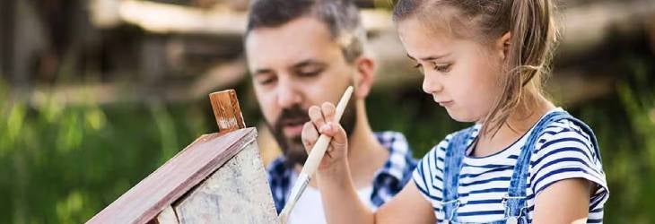 Niña realizando manualidades junto a su padre