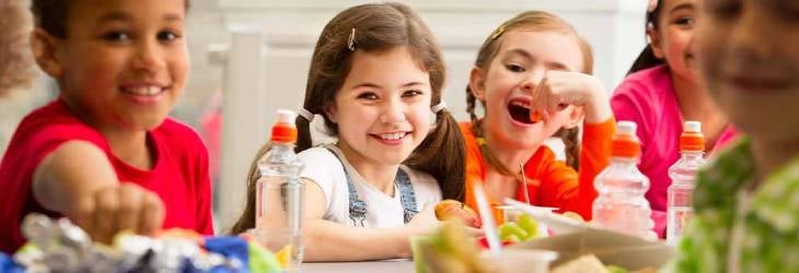 Niños concentrados en su merienda durante el colegio