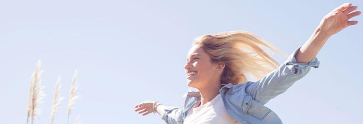 Mujer respira profundo, disfruta la naturaleza y da un paseo por su salud mental