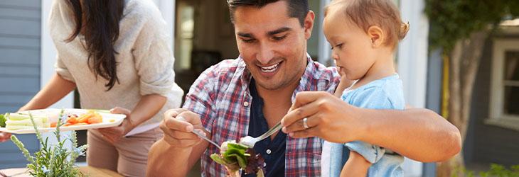 Una familia compartiendo tiempo mientras preparan la comida