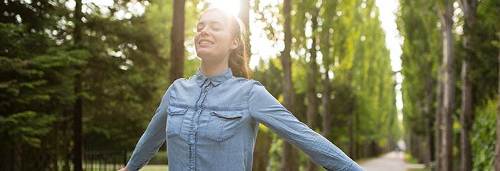 Mujer disfruta una caminata en el día en el parque para el beneficio de su salud